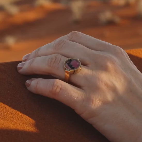 Australian rhodonite unisex ring worn on a hand in the outback at golden hour