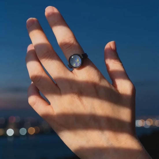 Australian opal unisex ring worn on a hand at blue hour, warm light falling across the skin