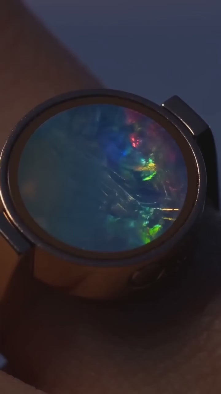 The Australian Opal Unisex Ring worn, its opal catching the light as the hand turns.